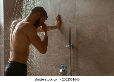 Portrait Of Nude Bearded Man Taking Shower Standing Under Steaming Hot Water Rain Washing Body In Modern Bathroom At Home, Free Copy Space. Male Beauty, Bodycare And Everyday Hygiene For Men Concept