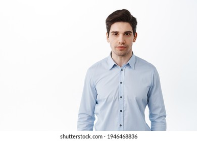 Portrait of office worker, corporate man entrepreneur standing in blue collar shirt with serious face, dark circles under eyes, looking tired, white background