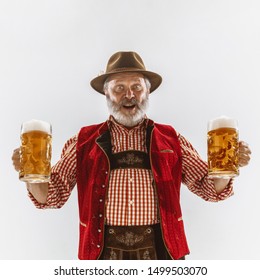 Portrait of Oktoberfest senior man in hat, wearing the traditional Bavarian clothes. Male full-length shot at studio on white background. The celebration, holidays, festival concept. Invites on beer. - Shutterstock ID 1499503070