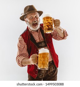 Portrait of Oktoberfest senior man in hat, wearing the traditional Bavarian clothes. Male full-length shot at studio on white background. The celebration, holidays, festival concept. Invites on beer. - Shutterstock ID 1499503088