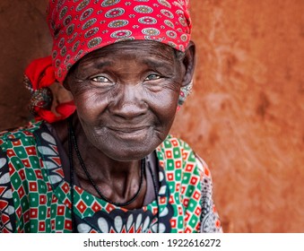 portrait of an old african woman sitting next to the wall in a village in Botswana