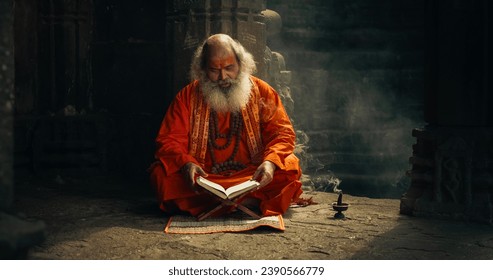 Portrait of Old Indian Monk Reading a Book in an Ancient Temple. Senior Guru Getting Wisdom from Sacred Texts, While Wearing a scarf Written: "Rattan Mohan Sharma Om Namah Shivay." - Powered by Shutterstock