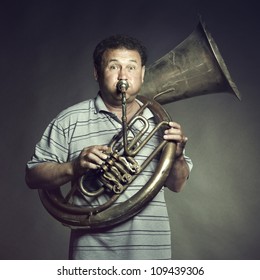 Portrait Of An Old Man Close Up Playing The Trumpet. Studio Photo