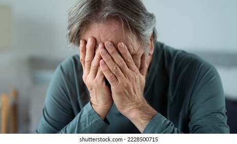 Portrait of old man covering his face with his hands - Shutterstock ID 2228500715