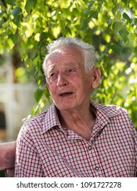 Portrait Of Old Man Crying On Bench In Park 