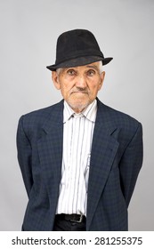 Portrait Of An Old Man With Hat Over Gray Background