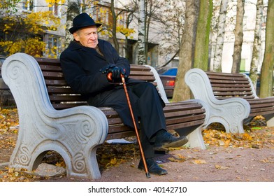 Portrait Of An Old Man In A Hat Sitting On A Bench