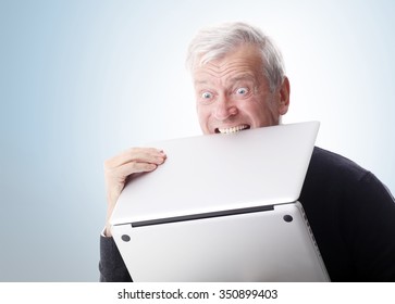 Portrait Of Old Man Holding Laptop In Hand While Frustrated With His Computer. 
