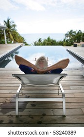 Portrait Of An Old Man Stretched Out In Front Of A Swimming Pool