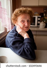 Portrait of an old woman 85 years old, in the kitchen.