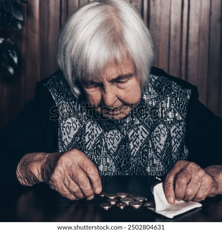 Portrait of an old woman counting money. The concept of old age, poverty, austerity