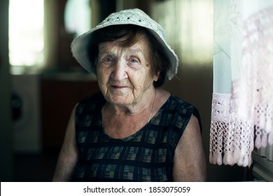 Portrait Of An Old Woman In The Kitchen Of Her House.