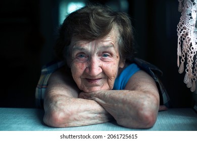 Portrait Of Old Woman Looking In The Camera In The Her Home, Close-up.