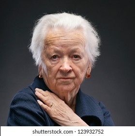 Portrait Of Old Woman On A Gray Background