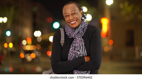 A Portrait Of An Older African American Woman Laughing In The Cold Weather On A Busy Street Corner