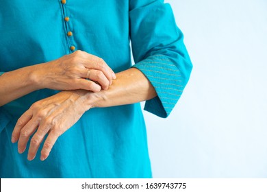 Portrait Of Older Asian Lady In Blue Blouse Getting Itchy From Skin Rash, White Background