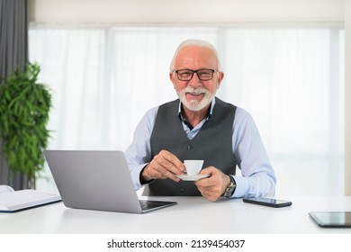 Portrait Of Older Business Man Holding A Cup Of Coffee Or Espresso Cup Looking Confidently At The Camera