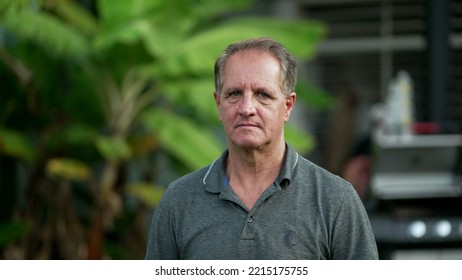 Portrait Of An Older Man With Serious Expression Standing Outdoors Looking At Camera. Closeup Senior Male Face