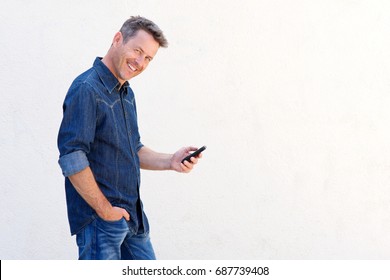 Portrait Of Older Man Smiling And Holding Mobile Phone