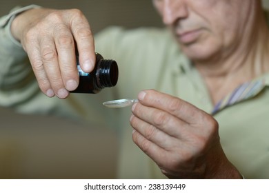 Portrait Of An Older Man Taking A Medicine