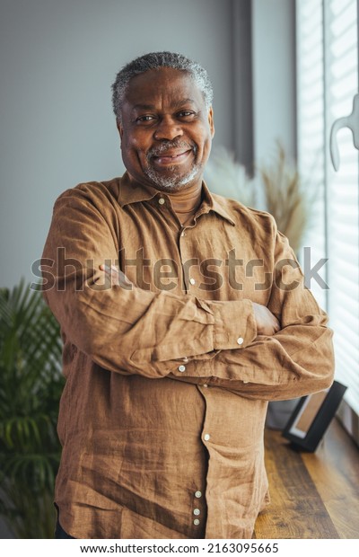 Portrait of an\
older man wearing a shirt on a gray background. A happy old man\
looks at a camera isolated over a gray wall. An older man smiles at\
the camera, a happy old man.\

