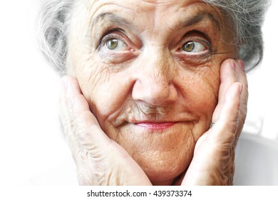 Portrait Of Older Pretty Woman With A Few Wrinkles. Touching Her Face With Hands