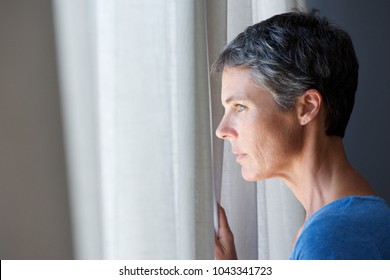 Portrait of older woman looking out window