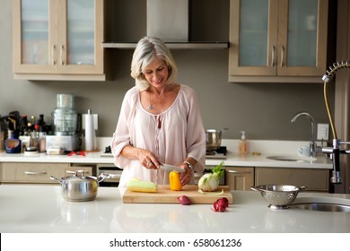 Portrait Of Older Woman Preparing Food For A Meal In Kitchen 