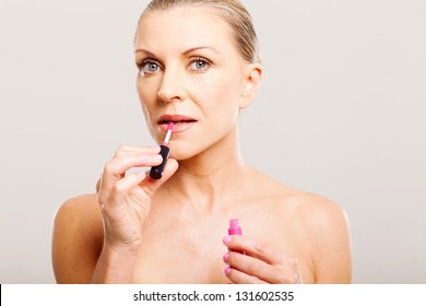 Portrait Of Older Woman Putting Lip Gloss Close Up