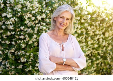 Portrait Of Older Woman Smiling And Standing Outside In Spring