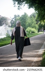 Portrait on back view of Veiled Muslim woman walking in the street 