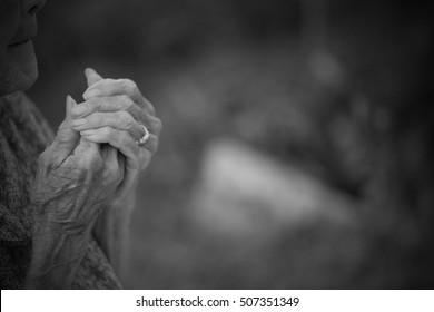 Portrait On Black Of Old Woman Praying.