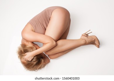 Portrait On White Background. The Girl Lies In The Fetal Position. Isolated