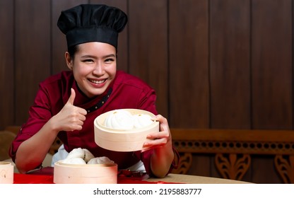 Portrait One Beautiful Traditional Professional Chinese Chef Wearing Red Uniform, Hat, Happily Smiling, Holding, Presenting Basket Of Food For Advertisement. Restaurant, Food, Hotel Concept