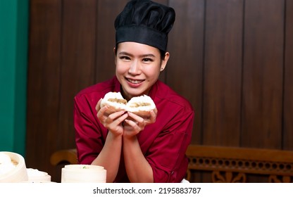 Portrait One Beautiful Traditional Professional Chinese Chef Wearing Red Uniform, Hat, Happily Smiling, Presenting Basket Of Food For Advertisement. Restaurant, Food, Hotel Concept