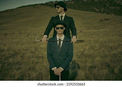 Portrait of one gentleman restraining another gentleman with a walking stick. Surrealist style. Valley background.