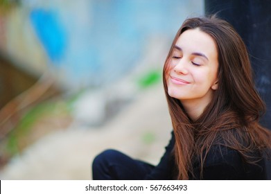 Portrait Of A One Happy Dreamy Beautiful Asian Woman Enjoy On The Street With Eyes Closed And Fun Cute Smile On Blurred Background Close Up Side View. Teen Fresh White Skin Care. Fall Real Nice Shot.