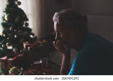 Portrait Of One Old And Mature Man Sitting On The Sofa Of His Home Celebrating The Christmas Day Alone And Lonely And Isolated From His Family For The Coronavirus