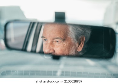 Portrait Of One Old Pensioner Man Driving And Enjoying His New Car. Rear View Mirror.