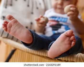 Portrait A One Year Children Foot On Background. Cute Baby Boy Legs Close Up Portrait. Littte Child Without  Socks And Shoes Sitting On Chair. Bare Feet Little Boy