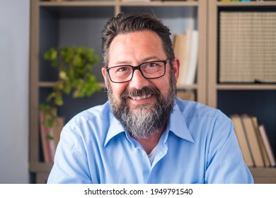 Portrait of one young and happy cheerful man smiling looking at the camera having fun. Headshot of male person working at home in the office.