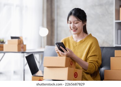 Portrait of Online business owner Asian female small businesses SME entrepreneur working at home, online marketing, packing boxes, SME sellers, concept, e-commerce team, online sales. - Shutterstock ID 2265687829