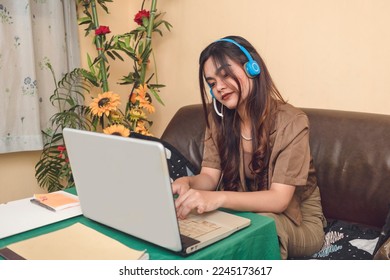 Portrait of an online worker. Using her laptop and headset as tools of communication to connect to other people.