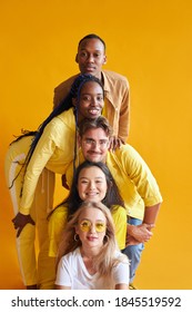portrait of open-minded people of different nationalities having fun, in positive mood, close friendship of african american caucasian and asian youth, isolated yellow background