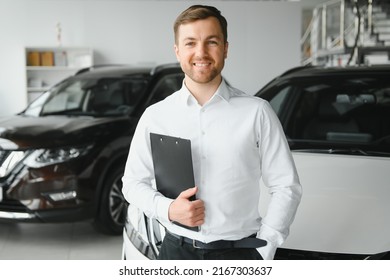 portrait of open-minded professional salesman in cars showroom, caucasian man in white formal shirt stands next to luxurious car and looks at camera. - Powered by Shutterstock