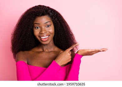 Portrait of optimistic brunette nice lady point hold empty space wear pink top isolated on pastel color background