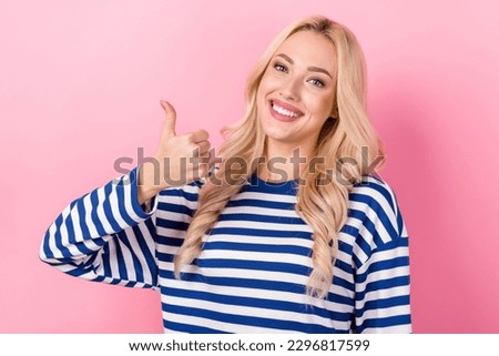 Portrait of optimistic satisfied girl with curly hairstyle wear striped pullover showing thumb up isolated on pink color background