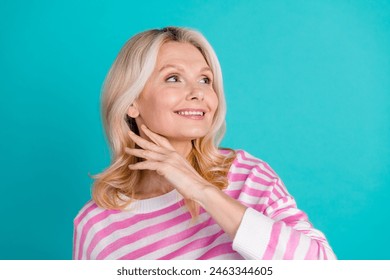 Portrait of optimistic senior person with wavy hairdo wear striped pullover look at logo empty space isolated on blue color background - Powered by Shutterstock