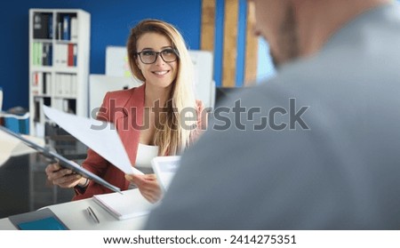 Portrait of optimistic woman discuss business papers with colleague, lady boss. Woman happy about company results. Business, career growth, success concept