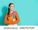 Portrait of optimistic woman wear orange crop top rucksack hug book look at proposition empty space isolated on turquoise color background